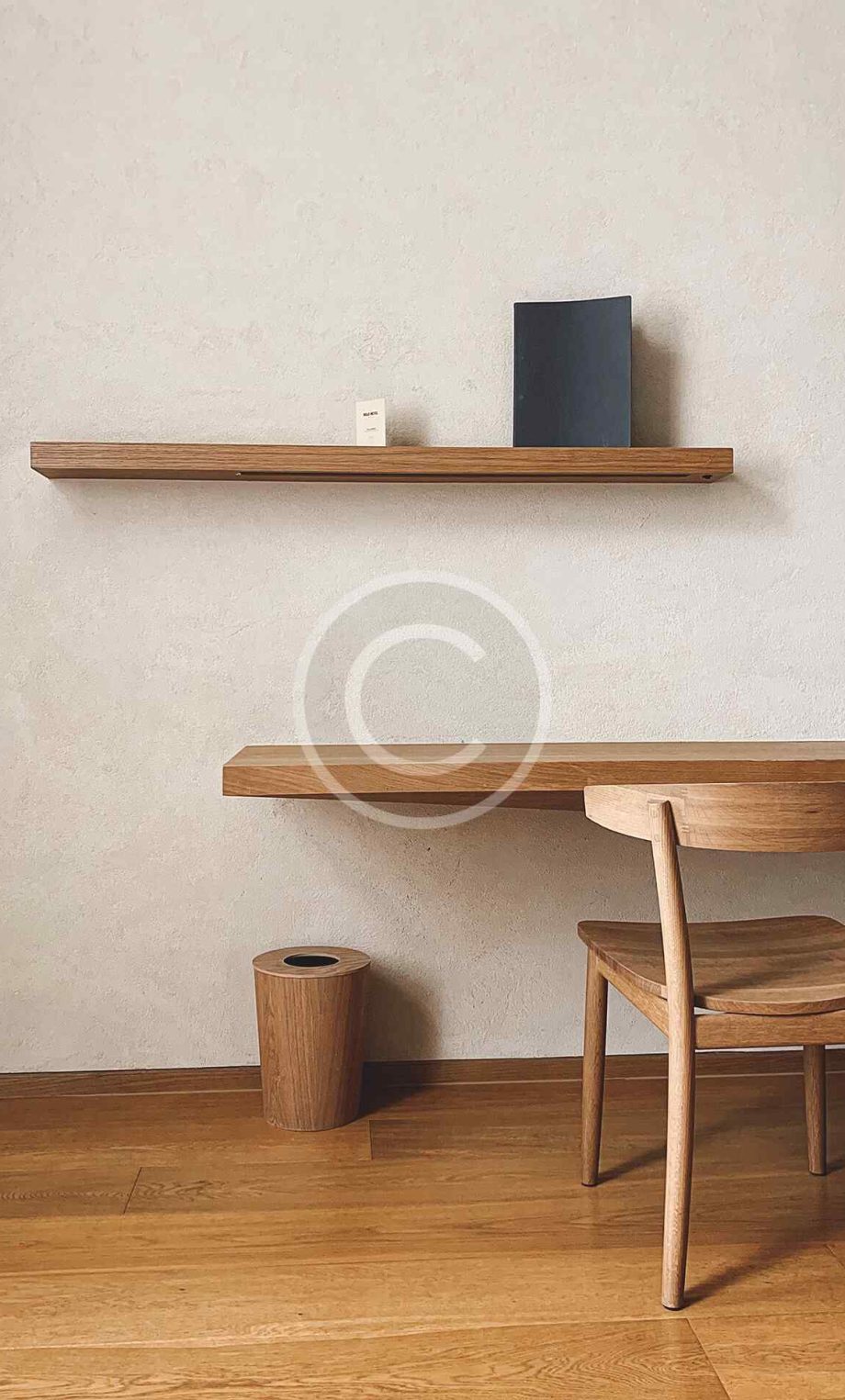 Minimalist dining area with wooden table and shelf.